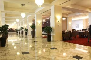 安曼大皇宫酒店的大堂的地板上摆放着桌子和盆栽植物