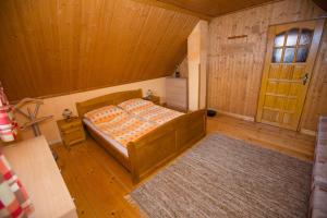 里托斯基挪威克Chata Beňušovce的木制客房内的一间卧室,配有一张床