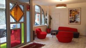 佩罗斯-吉雷克Hôtel de Perros, The Originals Boutique的客厅配有红色椅子和沙发