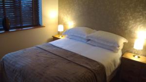 彼得伯勒Countryside Lodge的一间卧室配有带白色床单和枕头的床。