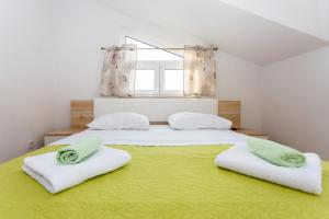珀德垂那Apartments Blaža的一间卧室设有两张带绿床单的床和窗户。
