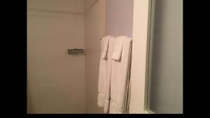 蒙特哥贝Anna's Joye Seawind - Freeport, Montego Bay的浴室设有悬挂在淋浴间的白色毛巾