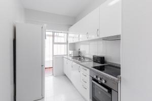 波尔图The Perfect Porto Apartment的白色的厨房配有炉灶和水槽