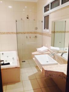 皮拉苏农加Habitat Hotel Pirassununga的浴室配有水槽、淋浴和浴缸。