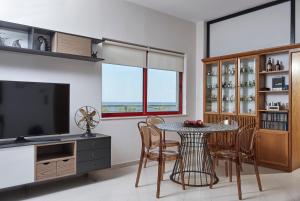 干尼亚维塔经典公寓的一间带桌椅和电视的用餐室