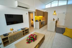阿皮亚托米西纳岛度假酒店的客厅配有电视和鲜花桌