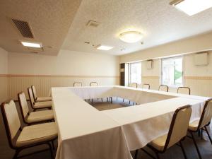 盛冈盛冈珍珠城市饭店的一间会议室,配有长桌子和椅子
