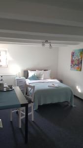 奥伊斯基兴多夫克鲁格旅馆的白色卧室配有床和书桌
