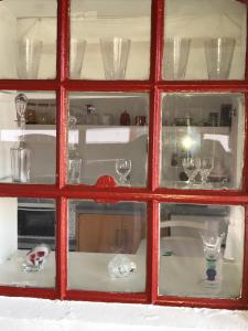 Havdrup波尔布洛民宿的红色的玻璃窗,有一堆玻璃杯