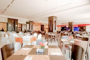 瓜拉丁加奴瓜拉丁加奴迷人酒店的一间设有白色桌子和白色椅子的餐厅