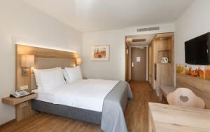 纽伦堡Holiday Inn Nürnberg City Centre, an IHG Hotel的一间卧室配有一张大床和电视