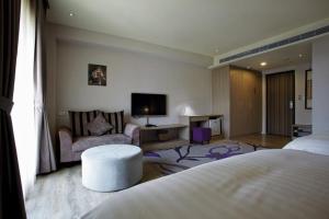 台中市米卡沙旅店的酒店客房配有床、沙发和电视。