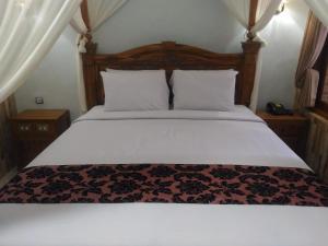 库塔索尔加别墅酒店的一间卧室配有一张大床和木制床头板