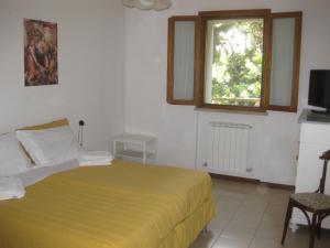 乌尔比诺Country House-B&B-Appartamenti Ai Cipressi的一间卧室配有一张带黄色床罩的床和窗户