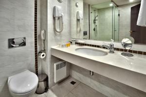 桑丹斯基桑丹斯基因特酒店的一间带水槽、卫生间和镜子的浴室