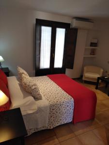Retuerta de Bullaque拉文塔德尔艾瑞鸥酒店的卧室设有红色和白色的床和窗户。