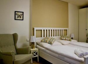 DrnholecHotel Drnholec的一间卧室配有一张床、一把椅子和闹钟
