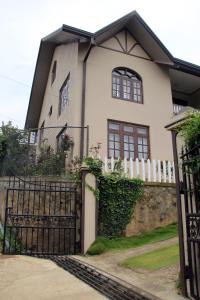 努沃勒埃利耶佩雷拉民宿的白色的房子,有门和栅栏