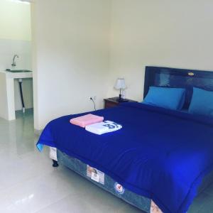乌鲁瓦图艾迪民宿的配有水槽的客房内的一张蓝色的床