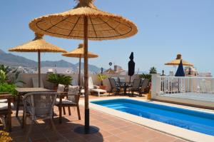内尔哈卡拉贝奥普拉亚别墅酒店的一个带遮阳伞和游泳池的庭院