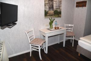 施塔德Hartlef´s Gasthof的配有桌椅和电视的客房