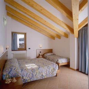安达洛Residence Alba Nova的一间带两张床的卧室,位于木天花板的房间