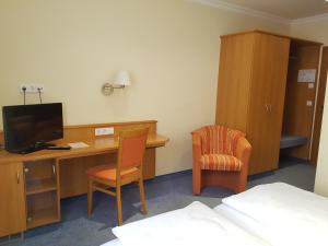 纽伦堡加尔尼凯穆尔酒店的客房设有一张桌子、一台电脑和一把椅子