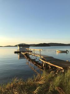 卢恩斯基尔Anfasteröd Gårdsvik - badstugor med loft的湖上码头,水中有两个船