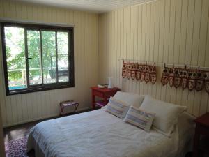 比亚里卡Casa Orilla Lago的一间卧室配有一张带白色床单的床和一扇窗户。