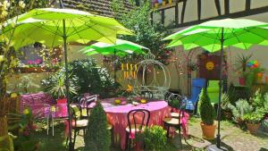 希伯维列La Tour Enchantée的花园内一张带绿伞的桌子和椅子