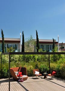 巴多利诺Aqualux Hotel Spa Suite & Terme的天井配有两把椅子和几把椅子