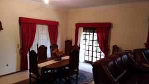 萨布罗萨Casa Deus的一间设有桌子和红色窗帘的用餐室