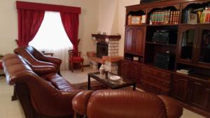 萨布罗萨Casa Deus的客厅配有真皮沙发和桌子