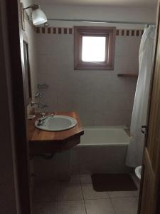 拉安戈斯图拉镇Villa Ålborg的一间带水槽和浴缸的浴室以及窗户。