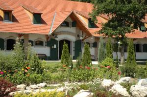 NemesnépAbbazia Country Club的一座带橙色屋顶和花园的房子