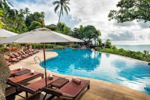 小通奈潘Panviman Resort Koh Phangan - SHA Extra Plus的一个带躺椅和遮阳伞的游泳池