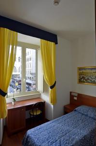 罗马特克斯酒店的一间卧室配有一张床、一张书桌和一个窗户。