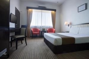 甲抛峇底赛莉马来西亚科帕拉巴塔斯酒店的酒店客房,配有一张床、一张桌子和椅子