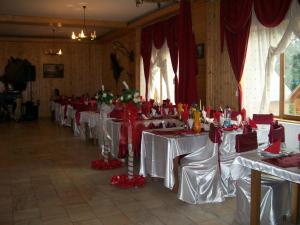 Căpăţîneni-UngureniComplex Dracula & Spa的红色和白色桌子设置的房间的一排桌子