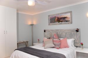 豪特湾The Salt House的卧室配有一张带粉色和灰色枕头的大床