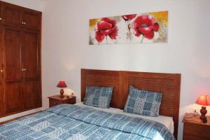 洛斯·亚诺斯·德·阿里丹Apartamentos Villa María的卧室配有一张挂着红色鲜花的床。