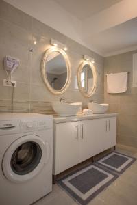 卡拉马基Aristodimos Luxury Apartments的一间带洗衣机和两个盥洗盆的浴室