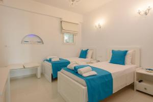 卡拉马基Aristodimos Luxury Apartments的白色客房的两张床,拥有蓝色调