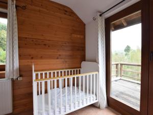VerpréDuplex Chalet in Rendeux Ardennes with Sauna and Terrace的木墙房间内的婴儿床