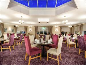 卡斯尔巴布拉菲酒店加Spa的一间带桌椅和紫色椅子的用餐室