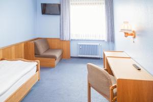 汉诺威普瑞米尔瑞卡拉斯汉诺威机场酒店的一间医院间,配有一张床和一把椅子