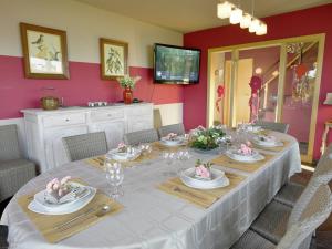 奥维法特Wonderful Holiday Home in Ovifat with Sauna的用餐室配有带盘子和玻璃杯的长桌