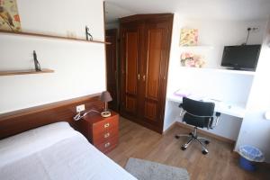圣地亚哥－德孔波斯特拉PR拉巴斯酒店的一间卧室配有一张床、一张桌子和一把椅子