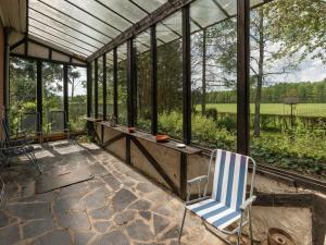 韦姆Holiday Home in Waimes with Private Garden的庭院中设有1个带蓝色和白色椅子的温室
