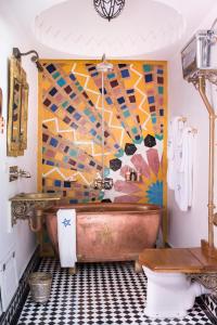 索维拉Salut Maroc!的浴室设有铜质浴缸和马赛克墙。